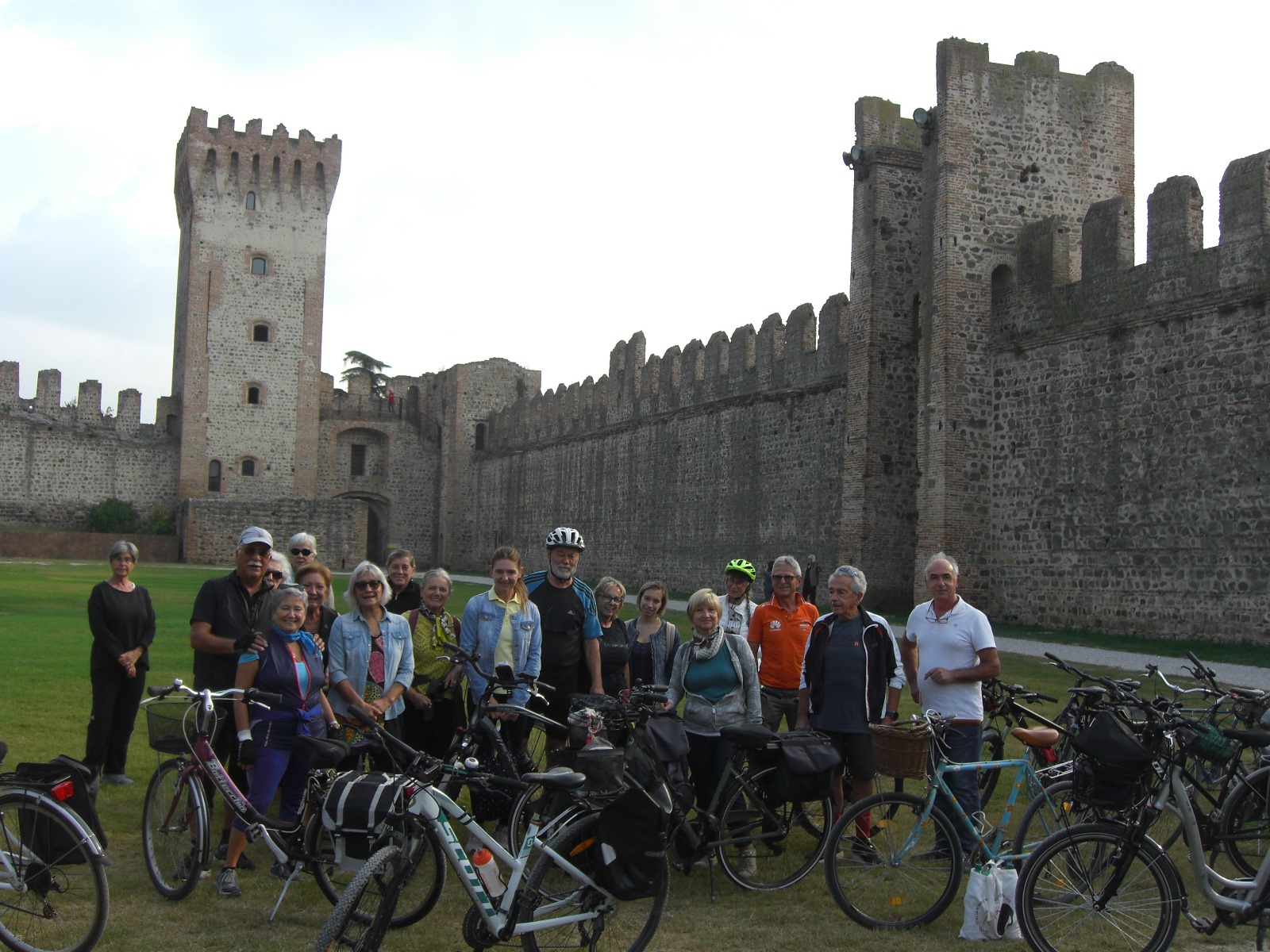 Gruppo di ciclisti in posa nel cortile interno di un castello medievale