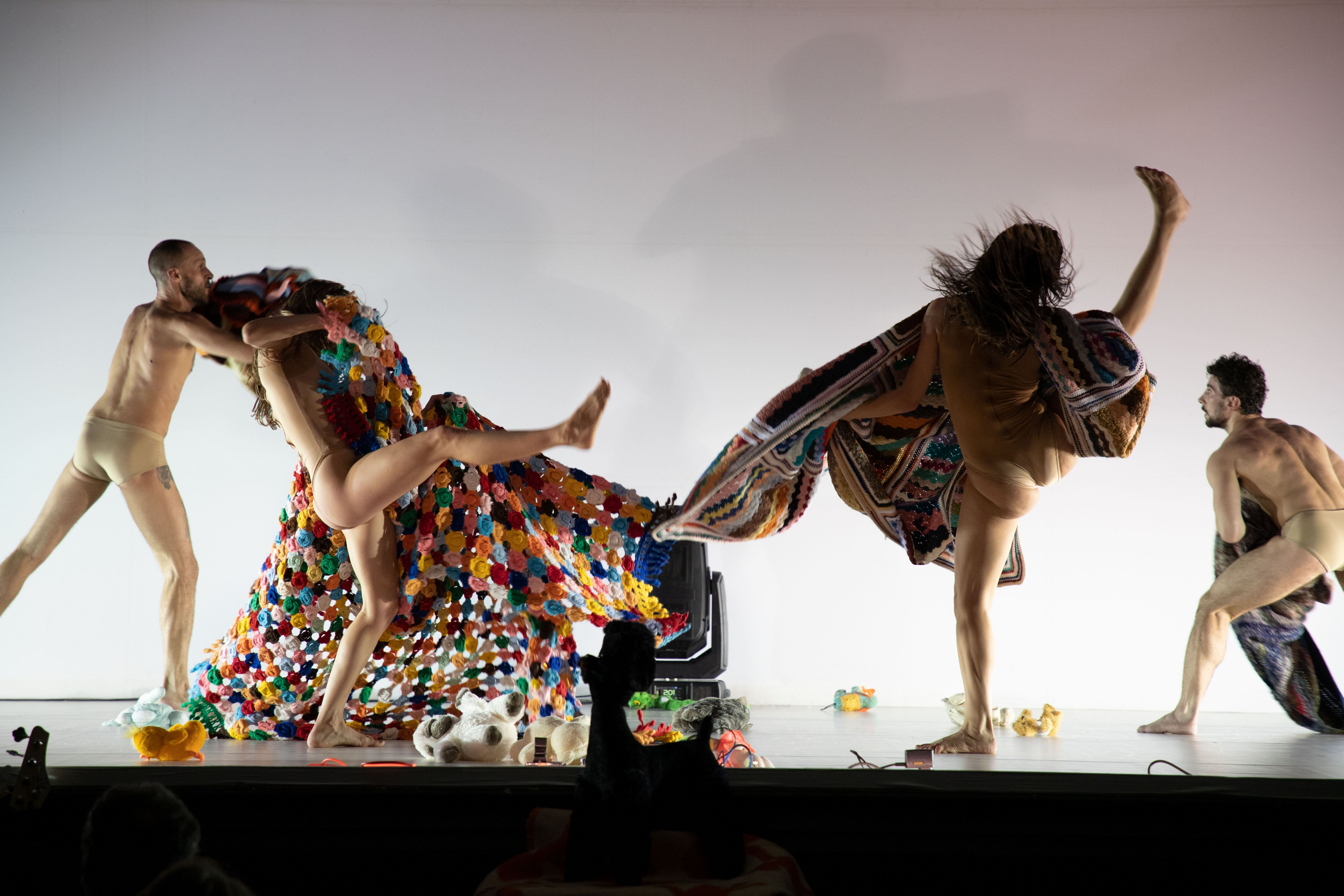 Quattro ballerini sul palco durante una performance di danza contemporanea