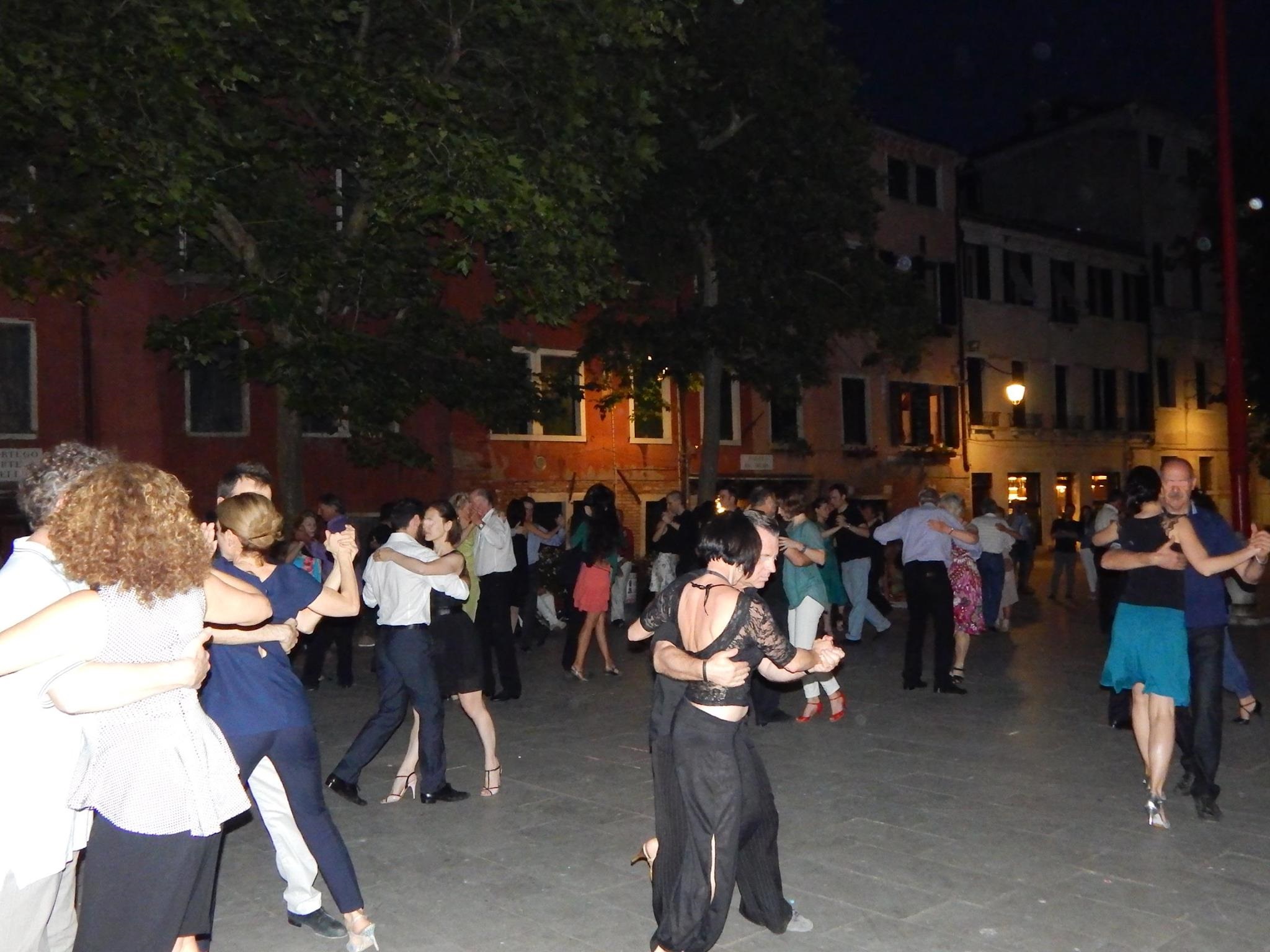 Numerose coppie ballano il tango in un campo di Venezia