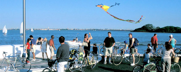 Foto di ciclisti a sud del Parco San Giuliano e sullo sfondo la laguna e alcune barche